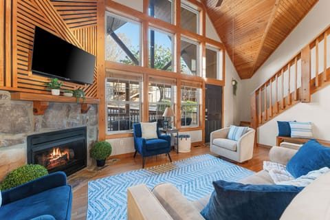 Relax in the stunning great room at Whitetail Lodge by Relax and Renew Rentals, with soaring ceilings, cozy fireplace and wall-to-wall windows. This vacation rental home near Silver Dollar City in Branson, MO is perfect for family gatherings and getaway!
