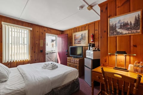 Welcome to your cozy Queen Room Retreat, featuring vintage pine paneling, a comfy bed with premium linens, and modern comforts for a relaxing stay.