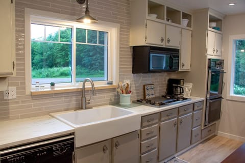 Main floor kitchen with refrigerator, double oven, microwave and dishwasher