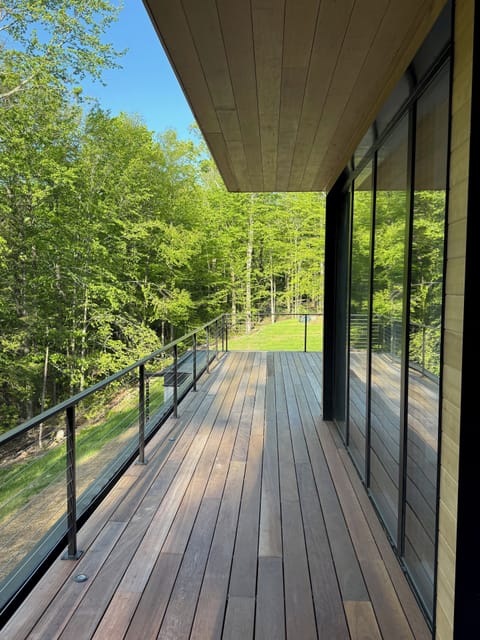Exterior Brazilian deck leads to large deck with chaise lounges.