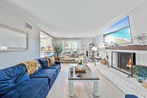 Relax in the bright living room featuring a cozy fireplace and large smart TV.