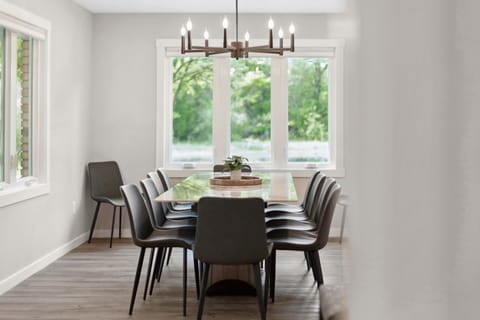 Gather around your elegant dining table for memorable meals, with natural light streaming through windows overlooking peaceful garden views.