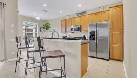 Contemporary kitchen with warm oak cabinetry and a sophisticated breakfast bar for elegant dining.
