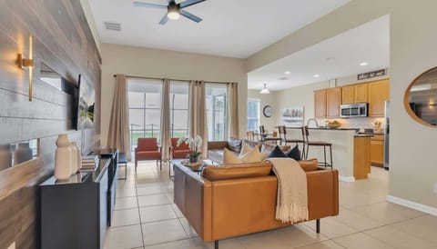 现代优雅的开放式起居室，温暖的皮革质感与精致的木纹背景墙完美融合。