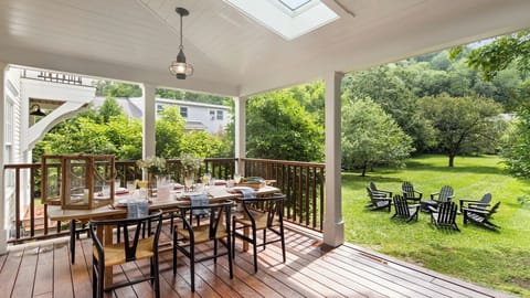 Enclosed porch with private dining and seating overlooking park like back yard.