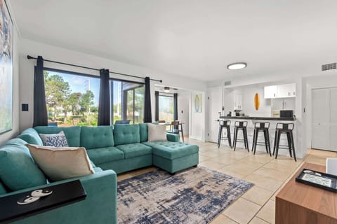 When you arrive, you’ll step right into a stylish living room featuring a comfortable L-shaped sofa that is perfect for lounging.