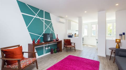 Step into a vibrant, stylish living room where modern design meets comfort. The bold geometric wall art and plush textures create a perfect setting to relax and unwind. #VibrantLiving #ModernDesign #LisbonStay