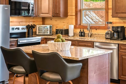 Fully equipped chef’s kitchen with granite countertops and bar seating.