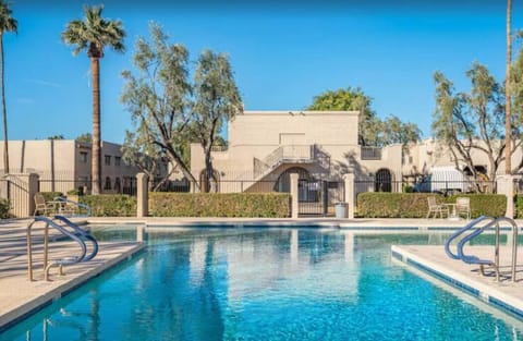 Sparkling outdoor pool with sunny lounging area and Mediterranean architecture