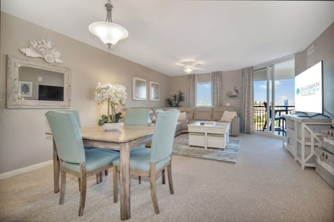 Relax in your spacious open-plan living space with elegant coastal décor, comfortable seating, and a dining area perfect for memorable meals together.