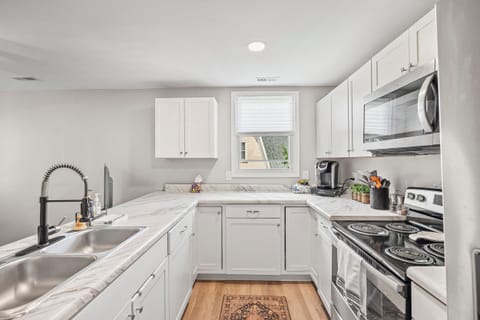 Full kitchen stocked with dishes, glasses, silverware, and cooking dishes