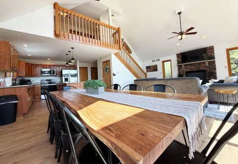 Open design flows from kitchen to living, dining, deck, and upper bedrooms.