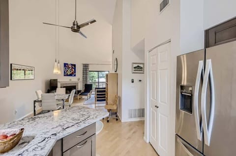 Open-flow layout from kitchen to dining table to living room, creating a spacious and welcoming environment
