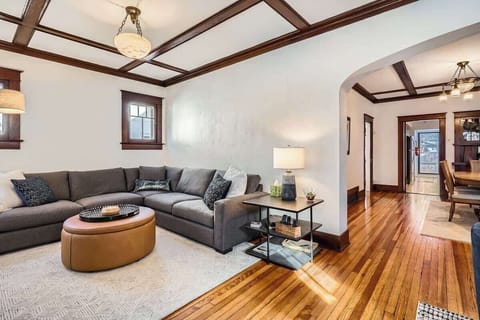 Spacious living room combining wood floors with a cozy rug for warmth and comfort