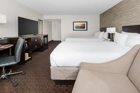Unwind in a spacious double-queen room with sleek workspace.