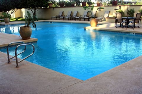 Unwind poolside in the sun with comfortable loungers nearby.