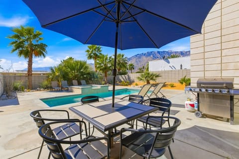 Outdoor dining patio with umbrella, grill and private pool