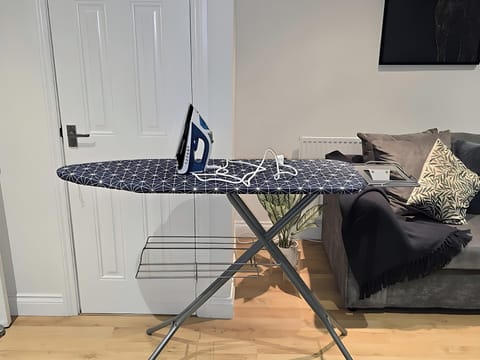 A beautifully furnished living room with comfortable sofas, a workspace with a table lamp, a 50-inch smart TV to entertain you with your favourite programmes on Virgin TV, a super-fast internet.