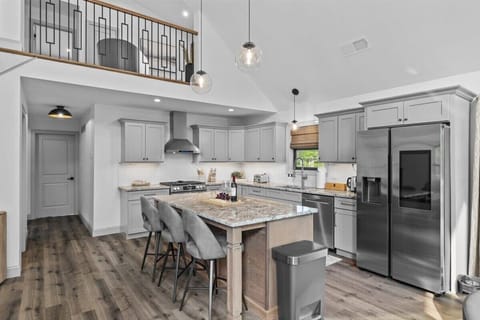 The chef's kitchen features a large island with bar seating and stainless appliances.