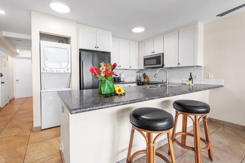 Updated kitchen with granite countertops, stainless appliances, and bar seating—perfect for island-inspired cooking.