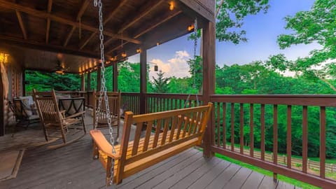 Unwind on the deck swing with forest views, rocking chairs & warm lighting!