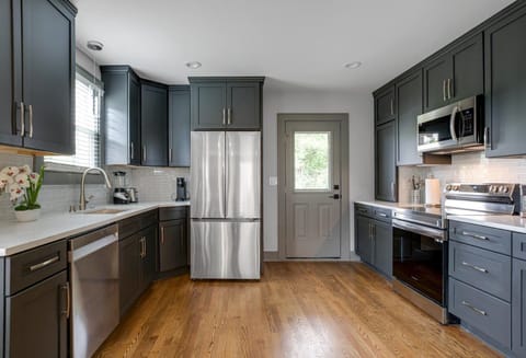 Fully equipped kitchen featuring stainless steel appliances and open counter space.