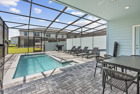 Step outside to the serene pool area, where stylish lounge chairs and shaded dining invite you to relax in the sun. The modern brick pavers frame the sparkling water, making it a perfect spot for sunbathing or a barbecue.