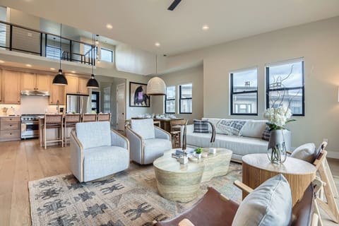 This open-concept living area features a stunning stone fireplace, cozy loft, and a modern kitchen. With high ceilings and plush seating, it’s the perfect space for group gatherings.