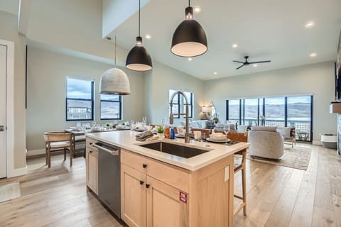 This luxury kitchen features a spacious center island with elegant seating, modern stainless steel appliances, and warm wood cabinetry. Stylish pendant lighting completes this inviting, gourmet space.