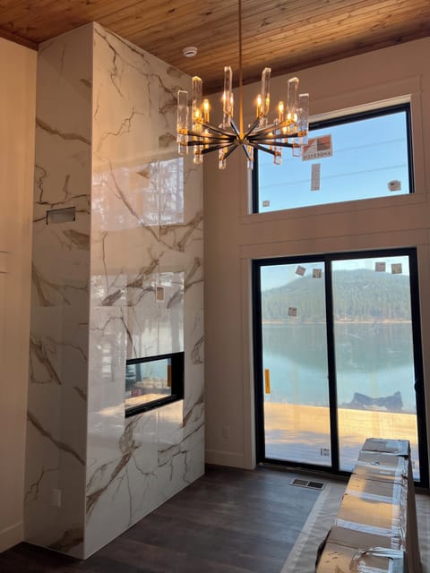 Primary bedroom with lake views and access to the deck and large fireplace.