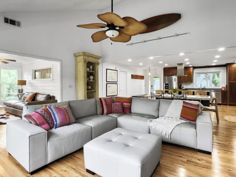 Spacious couch in living area with extra seats in sunroom.