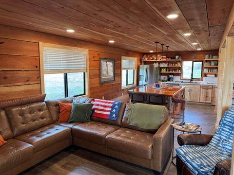 Open living space with large L-shaped couches, recliner and smart TV