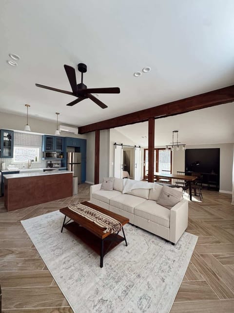 Second Floor: Living Space with an overhead fan, three seater couch, chair and coffee table in front of the TV.  Sliding doors with access to 2 small decks, seating will be provided in the warmer months. 