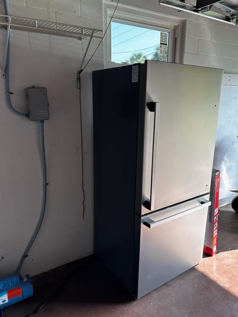 Full size refrigerator in garage.