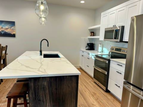 fully stocked spacious kitchen island with four inviting bar seats