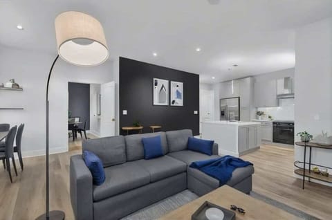 Modern and cozy living space with stylish decor, a comfortable sofa, and a sleek workspace. Perfect for relaxing or working remotely, with plenty of natural light and a warm, inviting atmosphere.