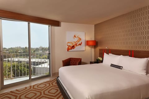 Wake to sunlight and balcony views from crisp king bed