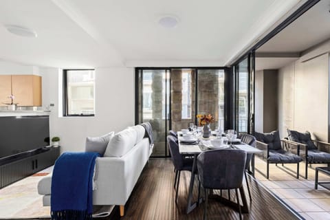 Relax in the open-plan living area with a comfy sofa and TV, dine at the elegant table nearby, or unwind on the balcony’s cozy lounge. These adjacent spaces flow together seamlessly for comfort and connection throughout your stay.