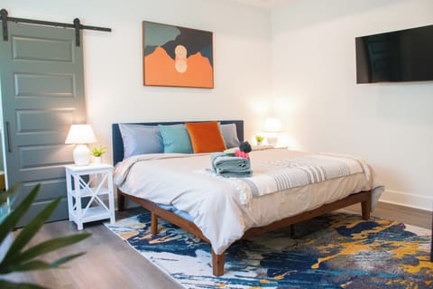 Enjoy the inviting comfort of the queen bed, adorned with soft linens and colorful accent pillows.