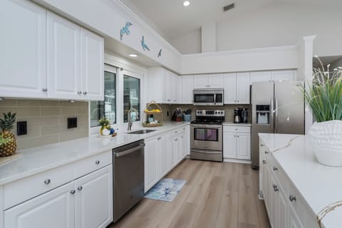 Step into this bright, coastal-inspired kitchen where you'll love preparing meals with modern stainless steel appliances and plenty of counter space. The cheerful nautical touches will make you feel like you're cooking by the sea.