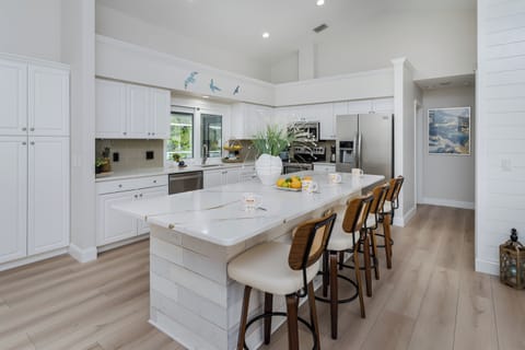Cook memorable meals in this stunning gourmet kitchen where white quartz countertops and stainless steel appliances create your perfect culinary workspace. Gather around the spacious island for morning coffee or evening conversations.