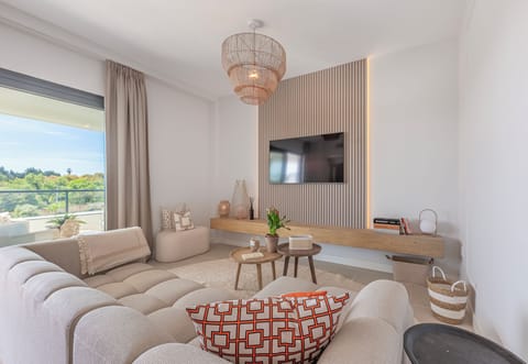 The living-dining room has a spacious sofa, table for 4, Smart TV, and balcony access. (1)