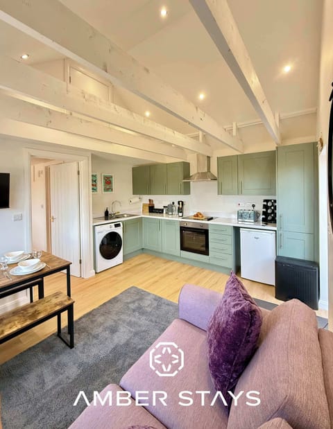 This living room stands out with its playful green and violet design. It’s a comfy spot to relax, watch TV, or just enjoy the cozy vibe.