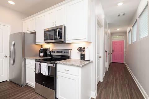 View of the fully stocked kitchen and hallway to the front door.