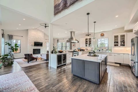 A spacious and inviting grand living room featuring a large smart TV, modern furnishings, and a cozy fireplace.