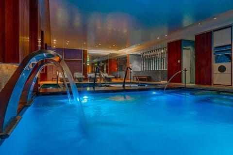 Dive into glowing waters with soothing cascades and loungers.