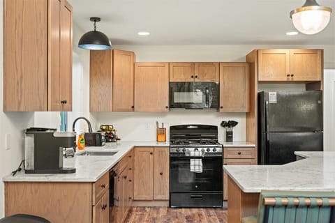 Whip up delicious meals in a fully stocked kitchen featuring a spacious island with high seating and top-of-the-line appliances—where cooking meets style and comfort.

