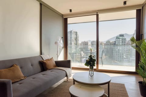 Relax in a stylish living room with stunning city and mountain views, perfect for unwinding after a day of exploring.