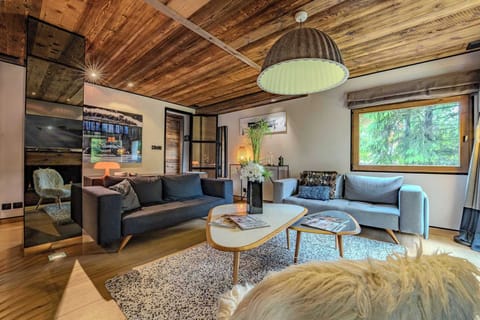 Dining area with panoramic windows—gather with loved ones and enjoy forest views and Megève’s unforgettable tranquility.