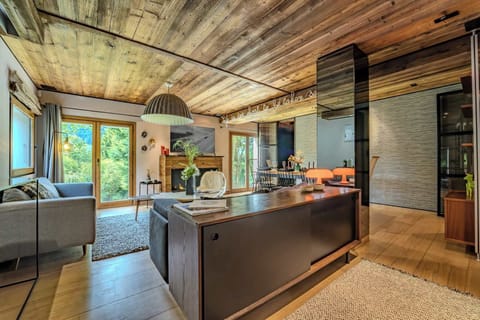 Bright and open living room in Megève with large windows and nature views—ideal for lounging, reading, or sipping hot cocoa after skiing.